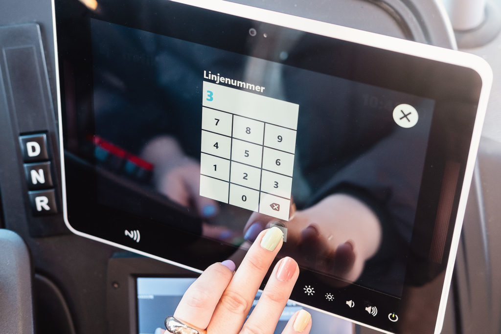Chaufför som ändrar linje på resa manuellt genom att trycka på digitala knappar på en skärm.